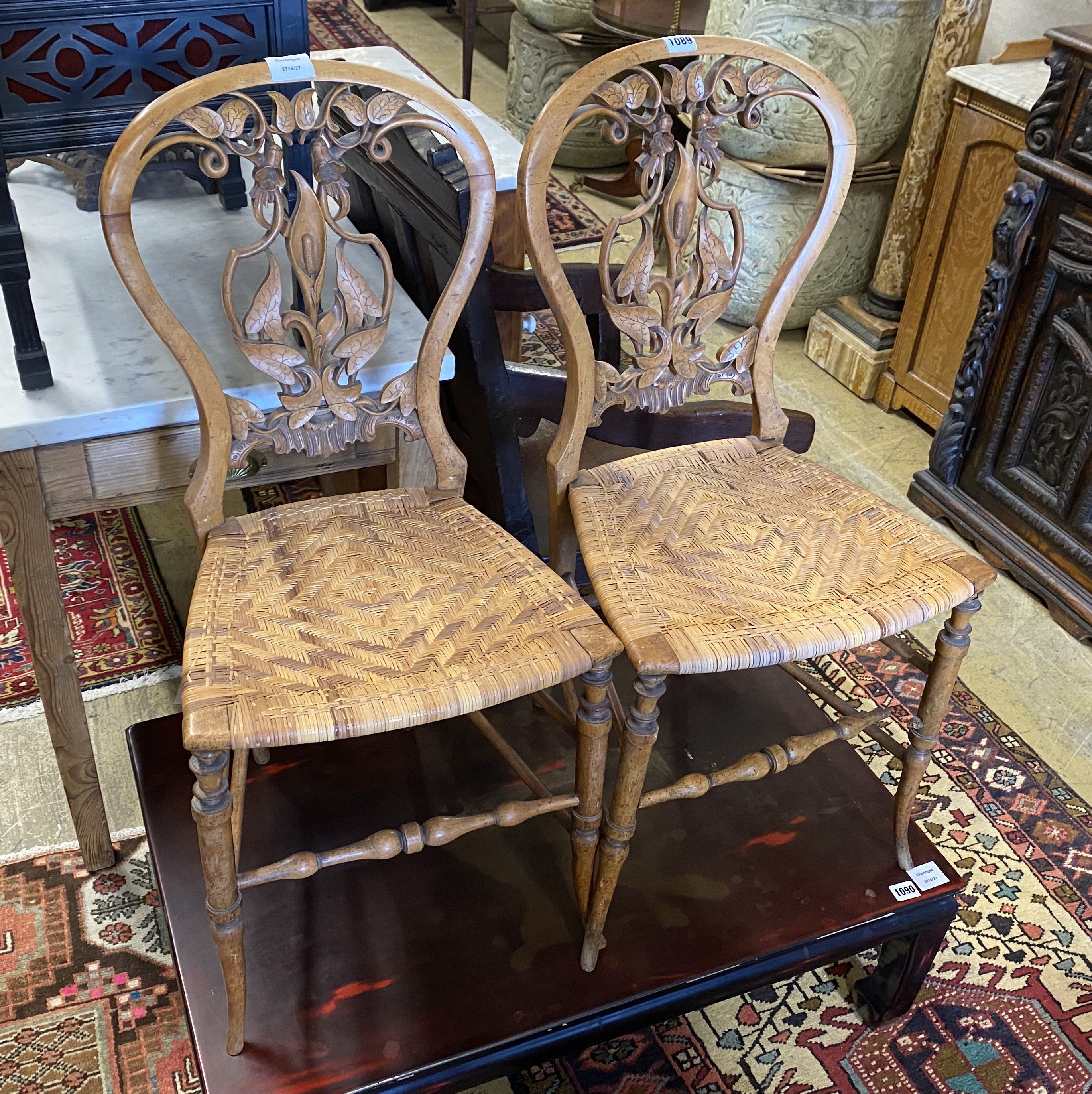 A pair of Victorian floral carved walnut cane seated side chairs